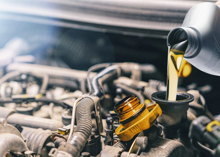 Pouring oil to car engine. Fresh motor oil poured during an oil change to a car. Kosten von überhitztem Motor